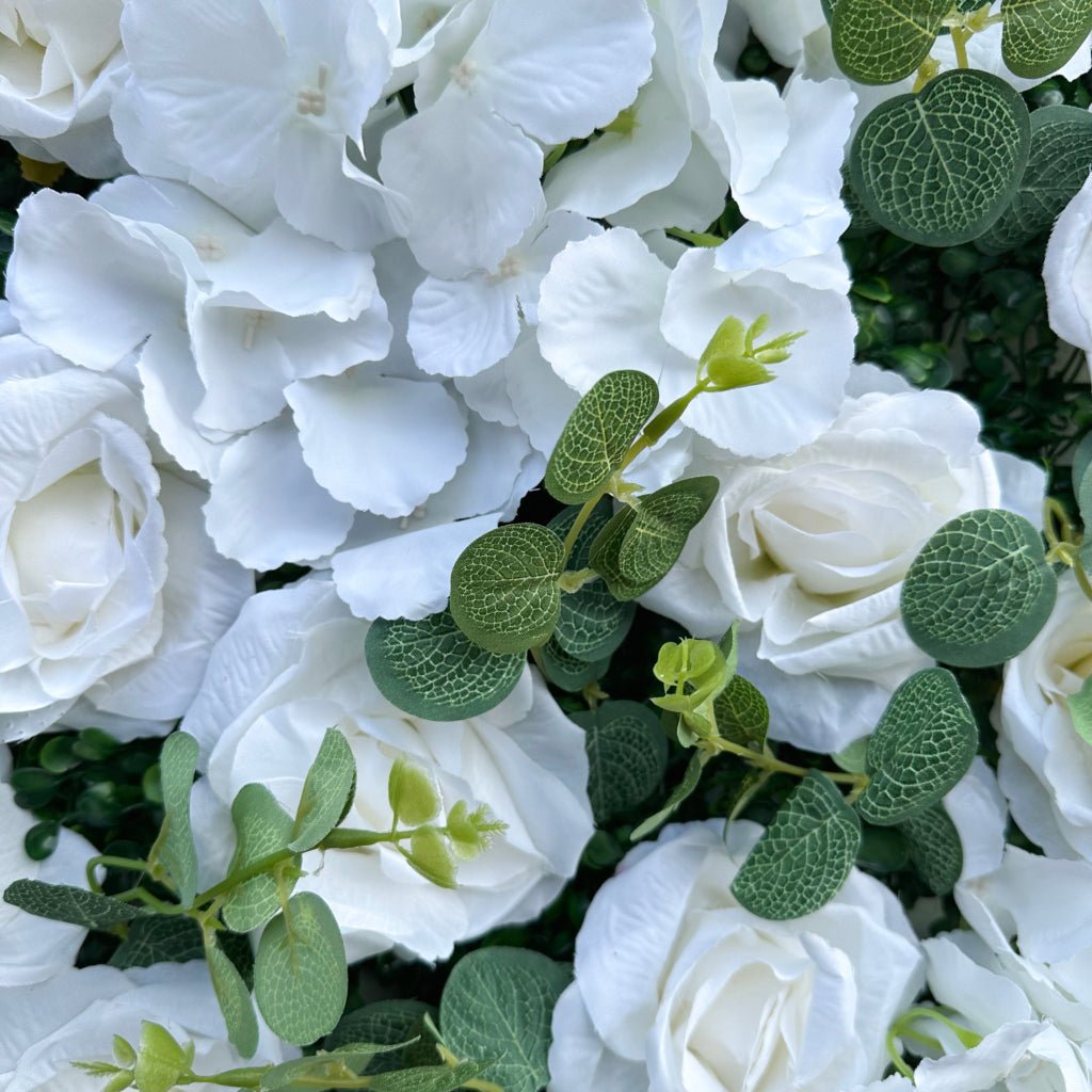 Close-up of white roses and hydrangea with green foliage on a flower mat
