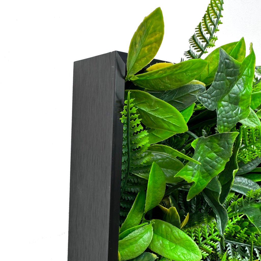 Artificial foliage wall art panel corner with bright green leaves on dark gray backing