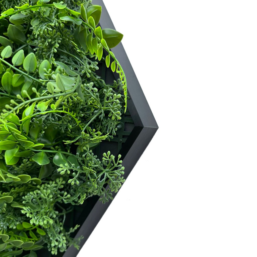 Artificial green foliage panel in black hexagonal frame, close-up of green leaves.