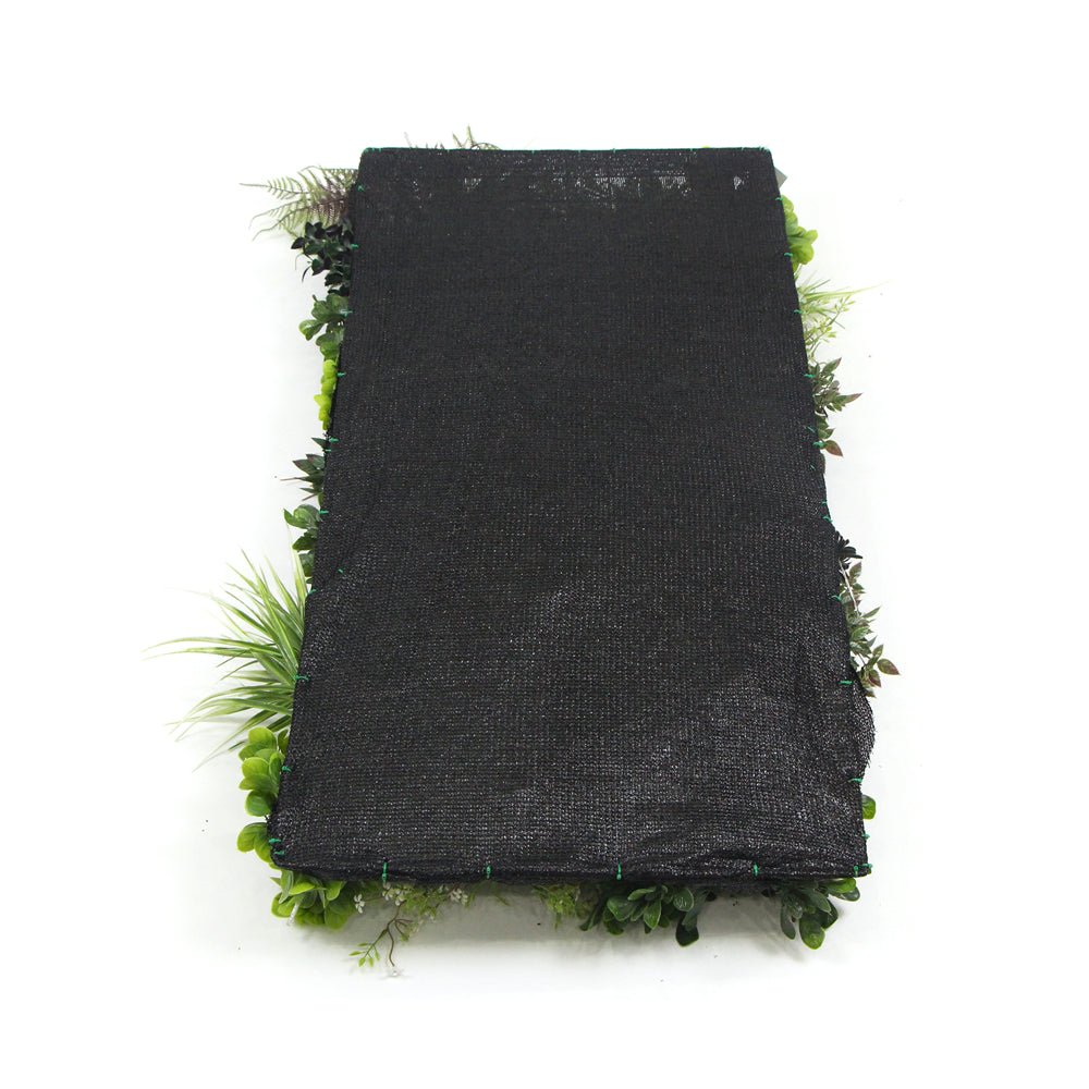 Artificial plant wall panel with dark backing and green foliage trim