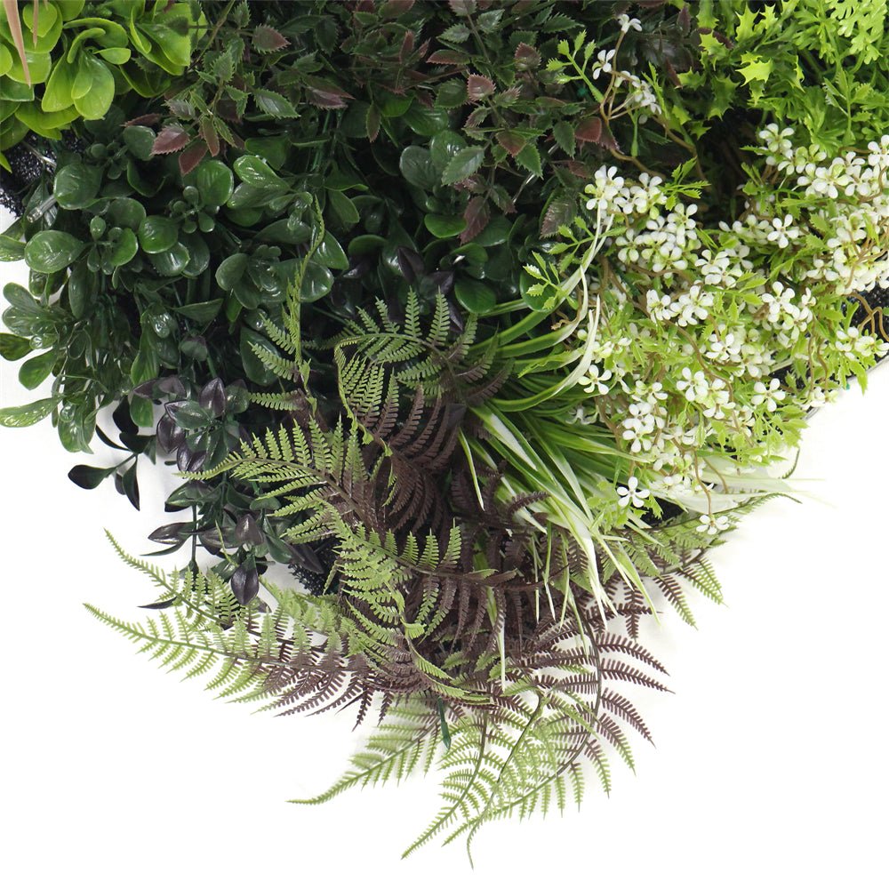 Artificial plant wall panel with layered green foliage, purple leaves, and white flowers