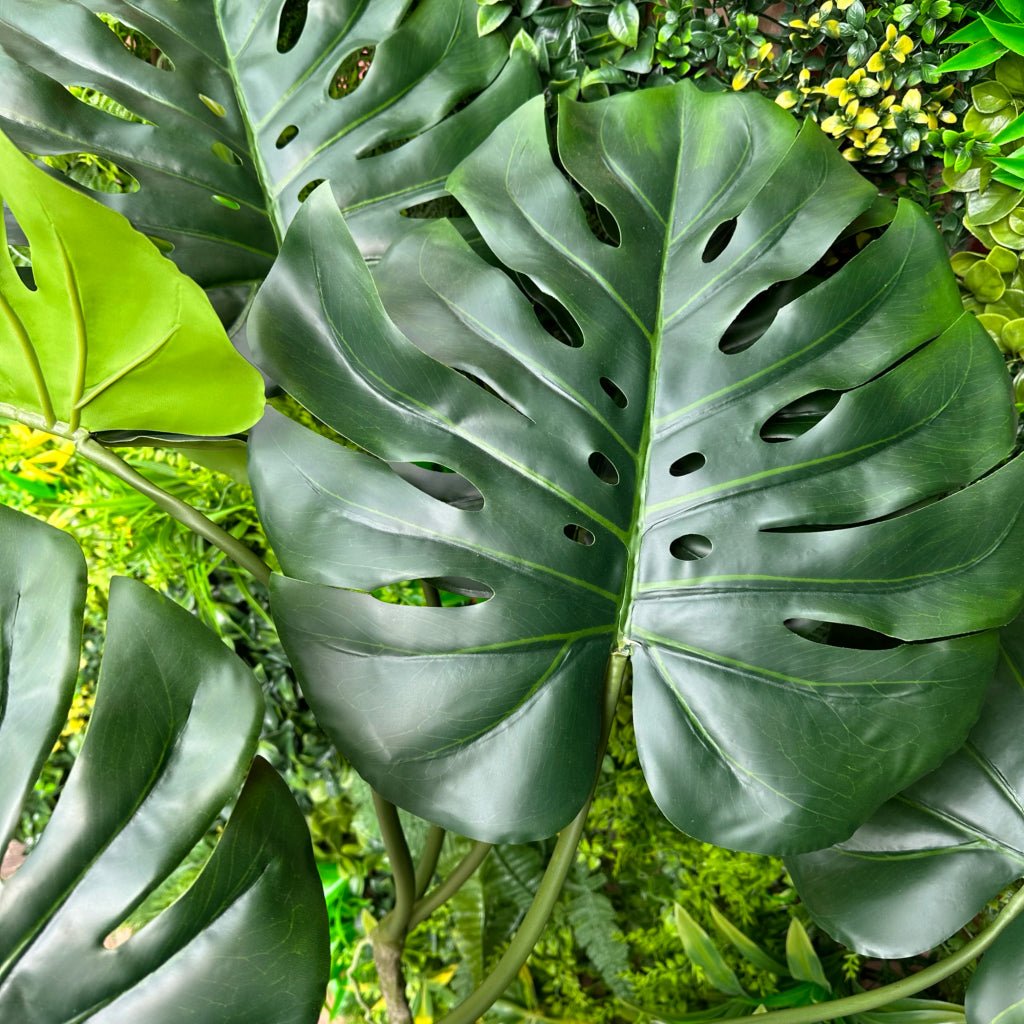 Artificial monstera leaf cluster with large green split leaves