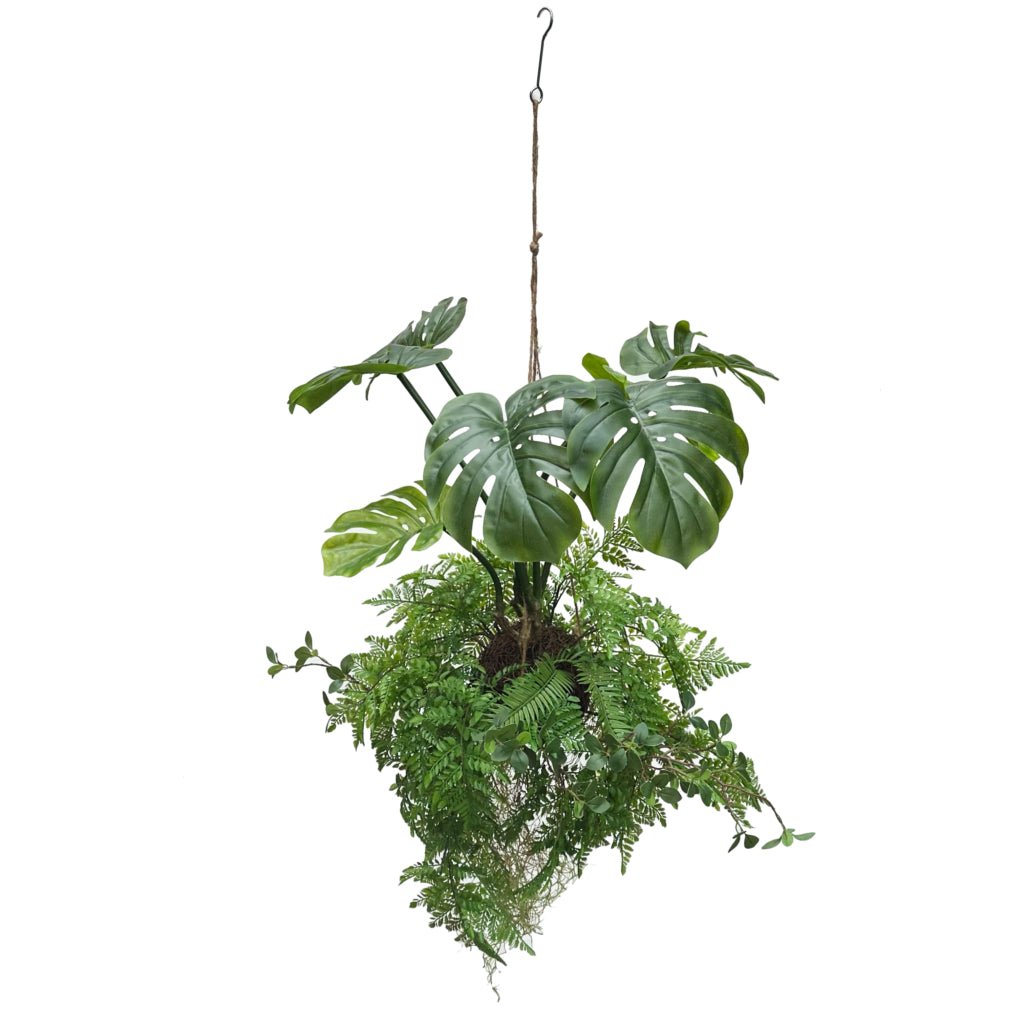 Hanging kokedama artificial plant with trailing ferns and green monstera-style leaves