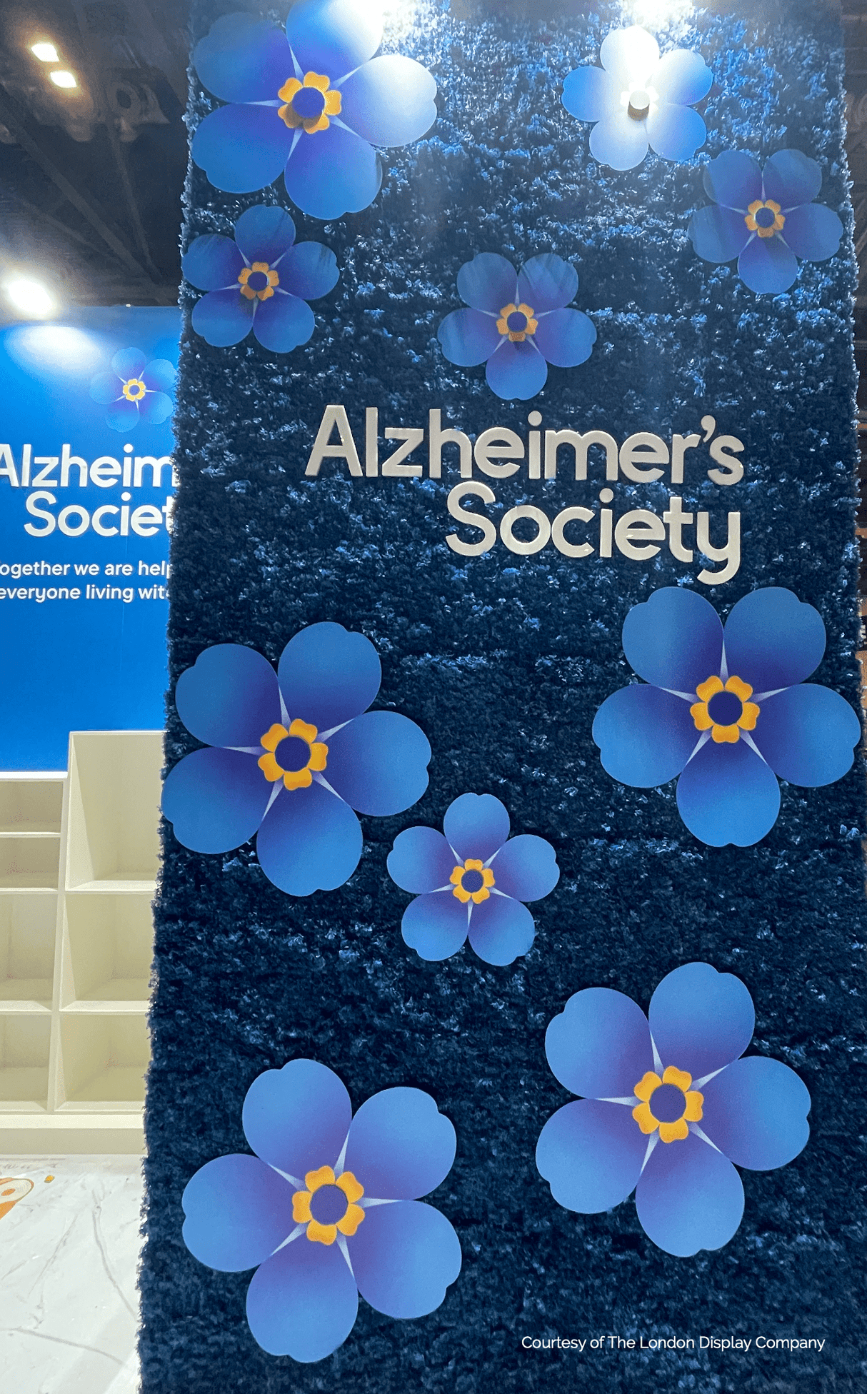 Blue moss panel with multiple paper flowers and 'Alzheimer's Society' logo