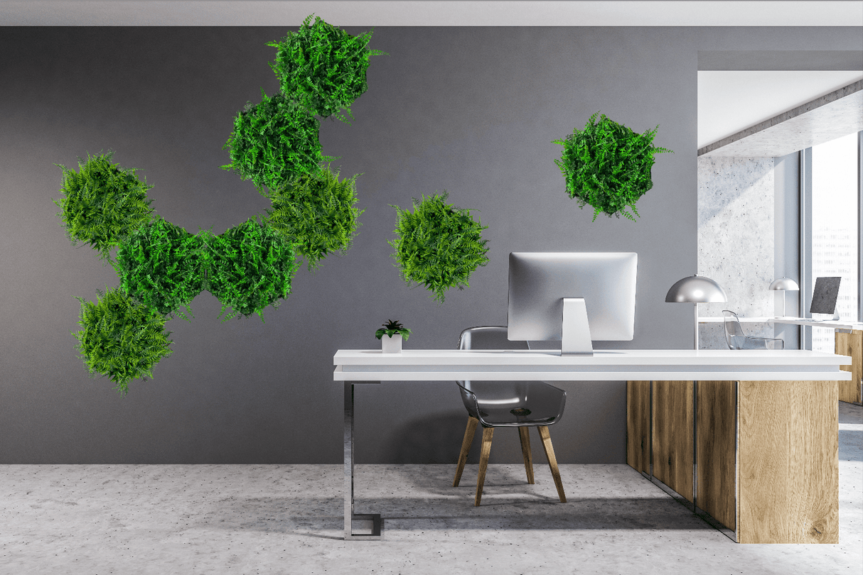 Artificial green fern foliage clusters with hexagonal aluminium frames on a wall.