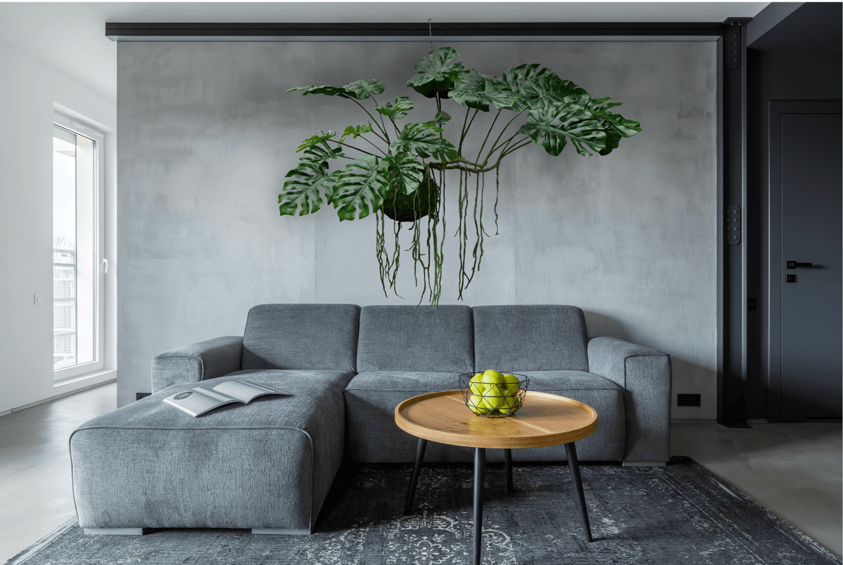 Artificial hanging monstera kokedama with green leaves and trailing roots