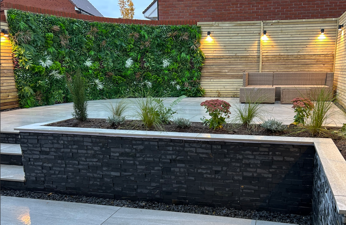 Artificial green wall panel with dense leafy texture in mixed green and dark foliage