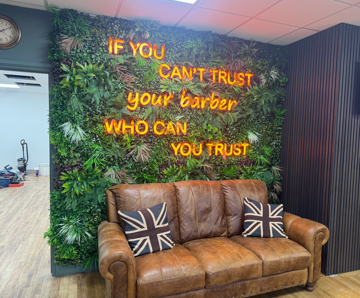 Artificial green wall panel with lush mixed foliage and white flower details in a hedge-style wall