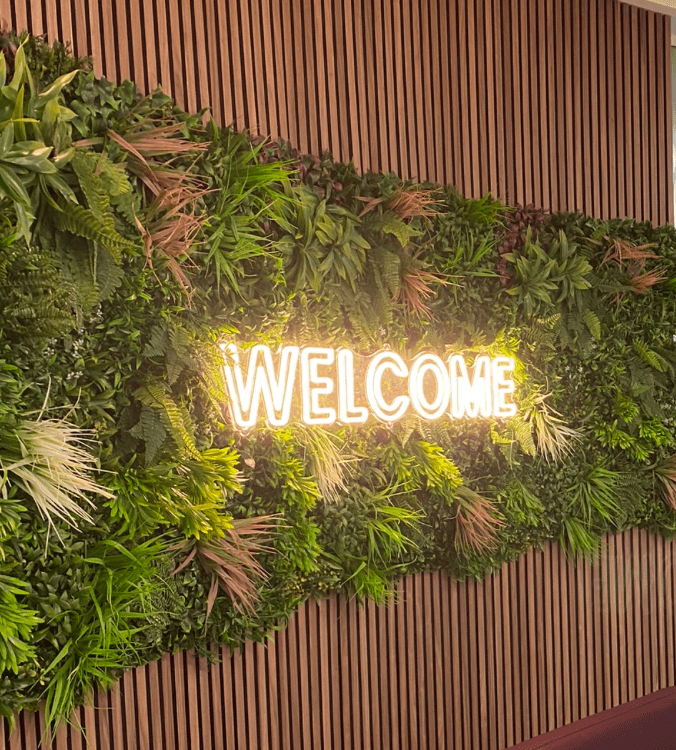 Artificial green wall panel with dense leafy foliage and fine frond texture on vertical slats