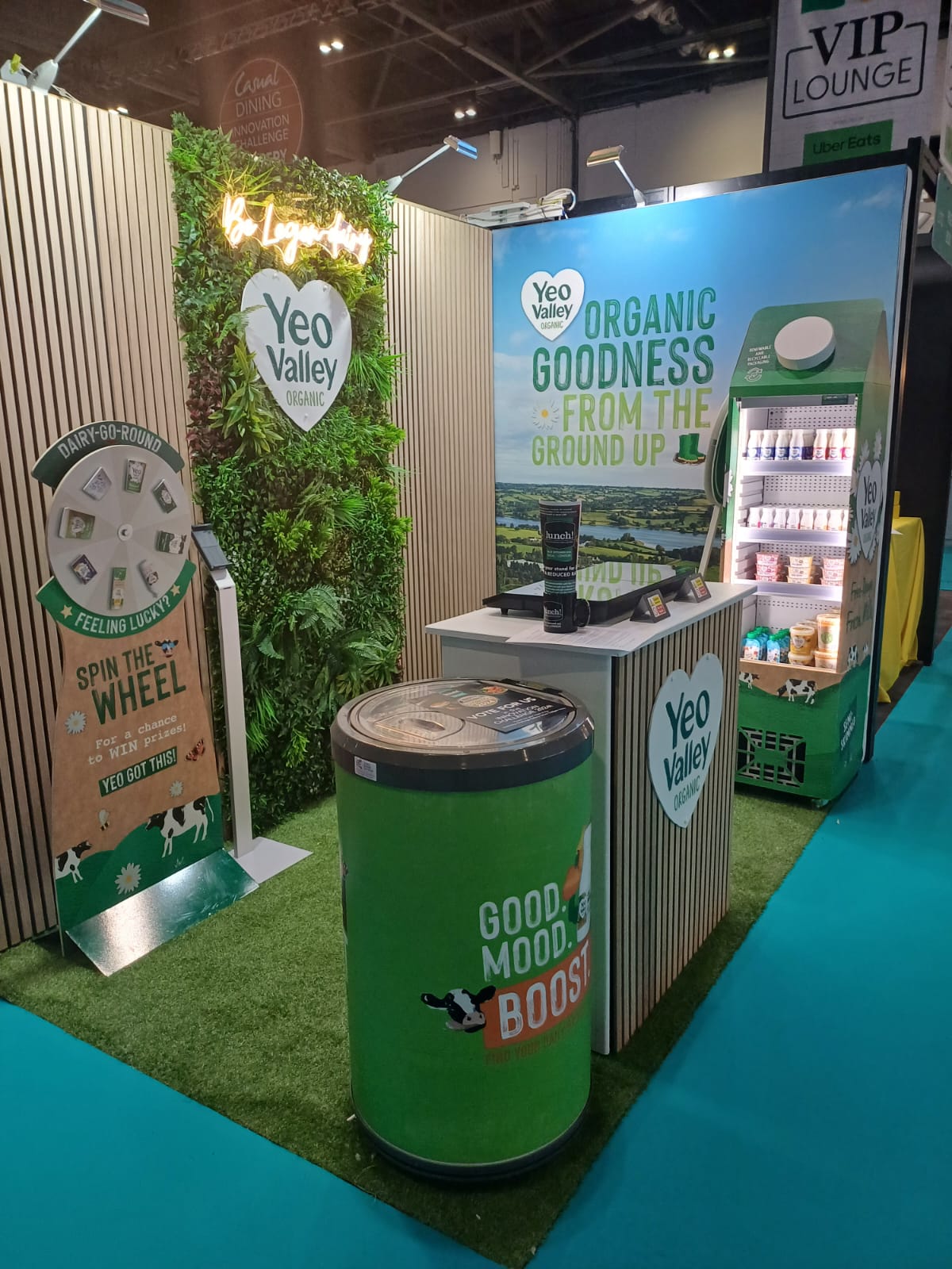 Artificial green wall panel with mixed foliage backdrop for a branded indoor display