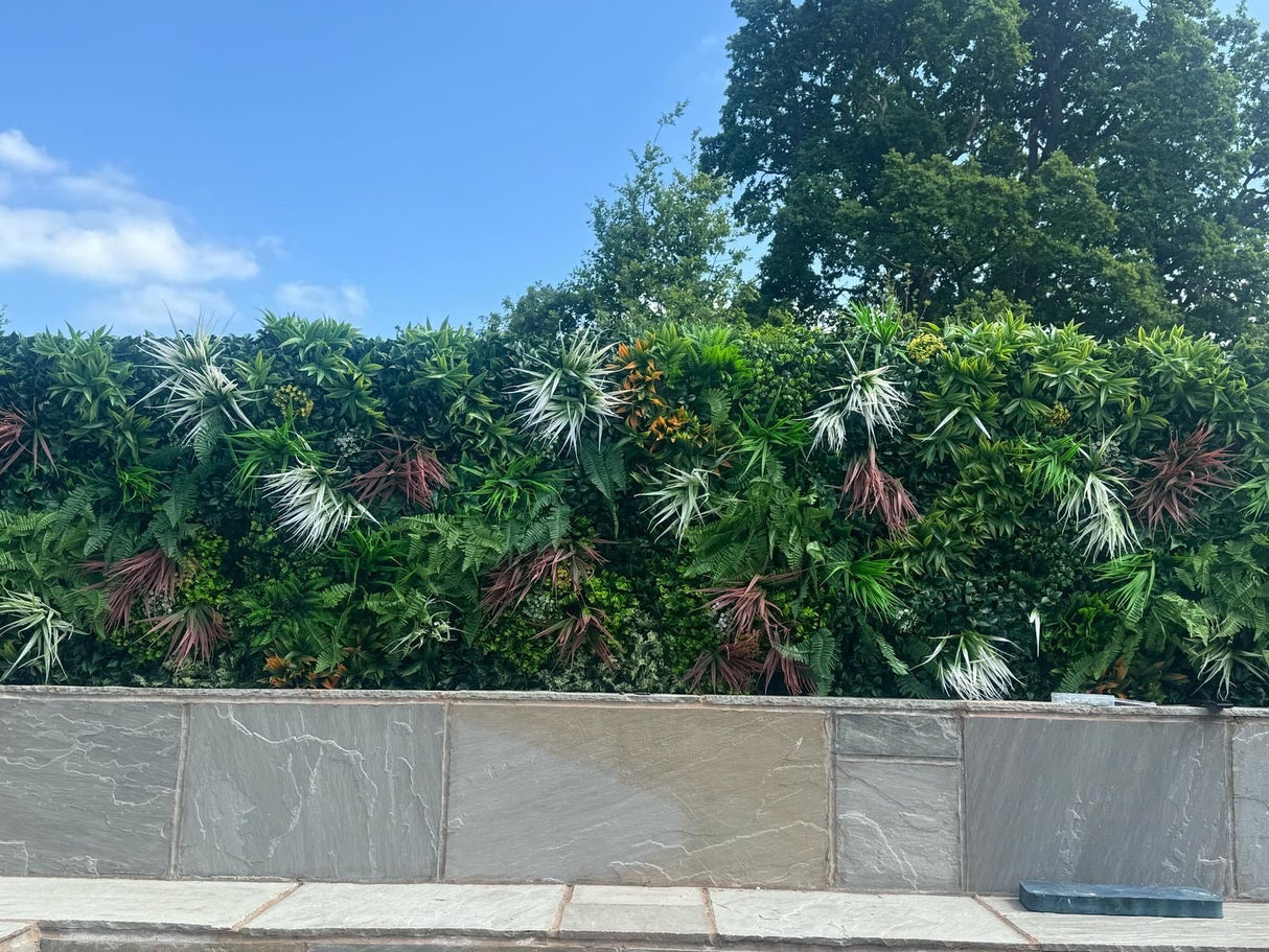 Artificial green wall panel with lush green foliage texture along a raised ledge