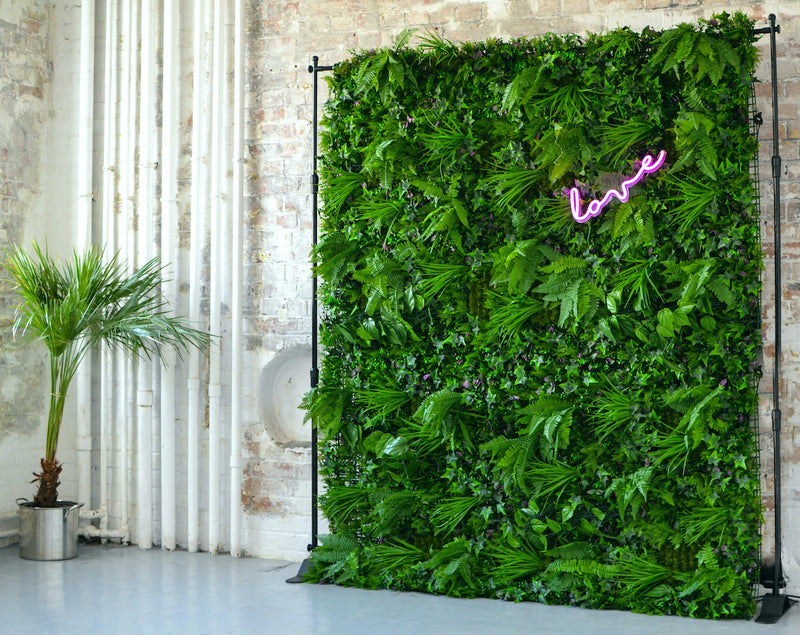 Artificial green wall panel with variegated greens of ivy, ferns, palm heads, grasses