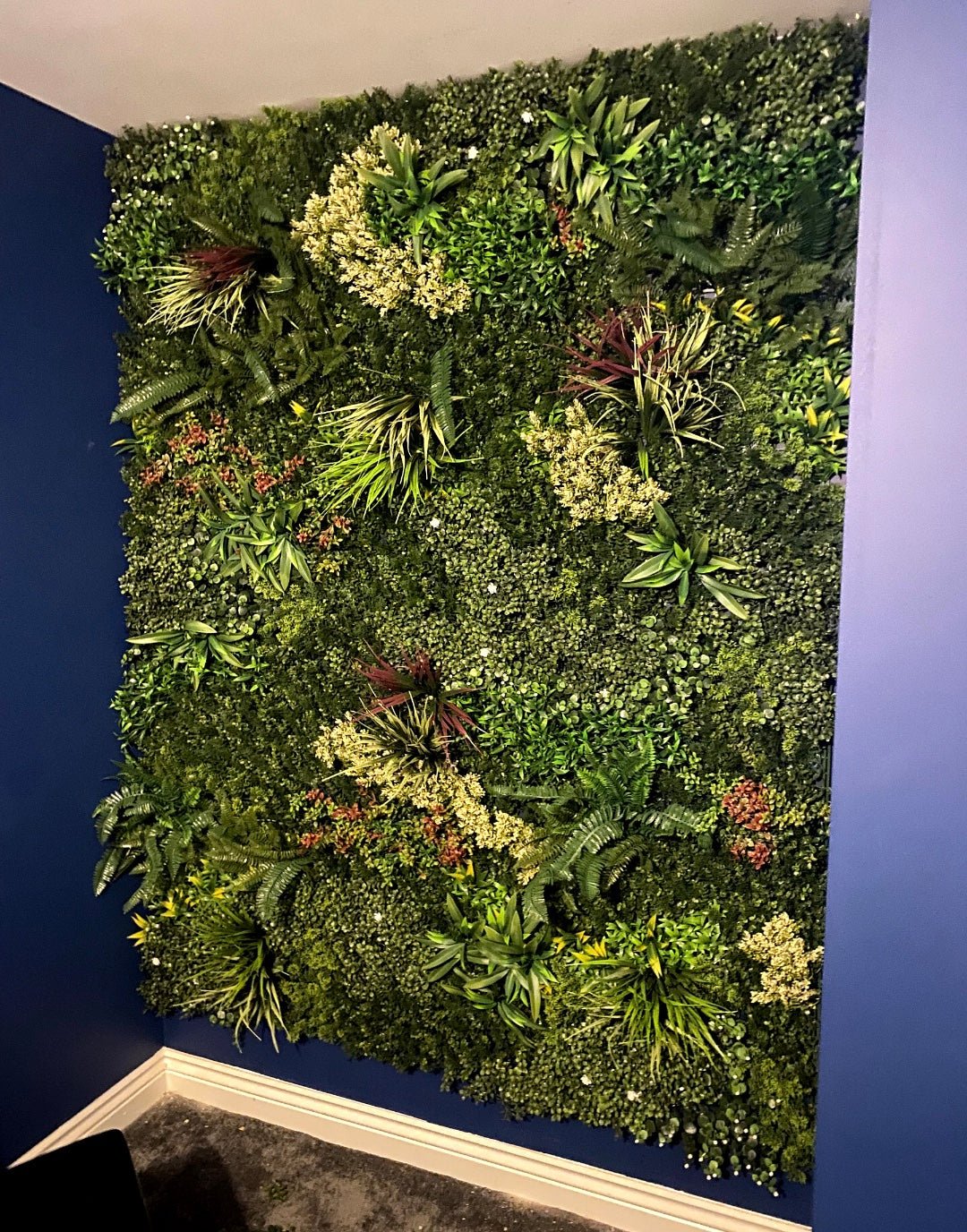 Artificial green foliage wall panel with variegated yellow, red, orange and white leaves
