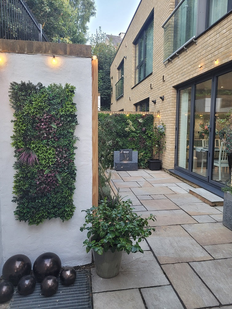 Artificial green wall panel with variegated greens of ivy, ferns, palm heads, grasses