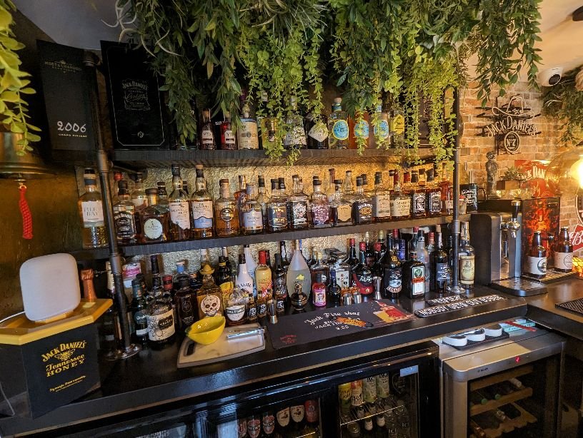 Artificial hanging green foliage curtain with layered trailing plants above a bar counter