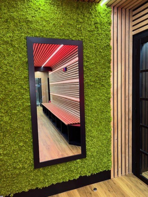 Artificial moss panel wall with green texture and a rectangular mirror opening