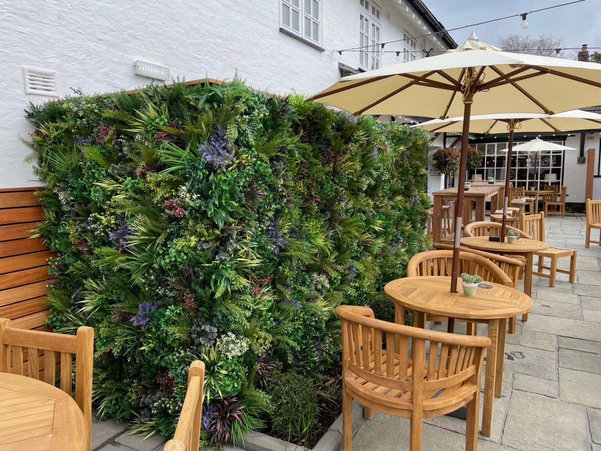Artificial green foliage wall panel with dense leaves and small yellow and white flowers
