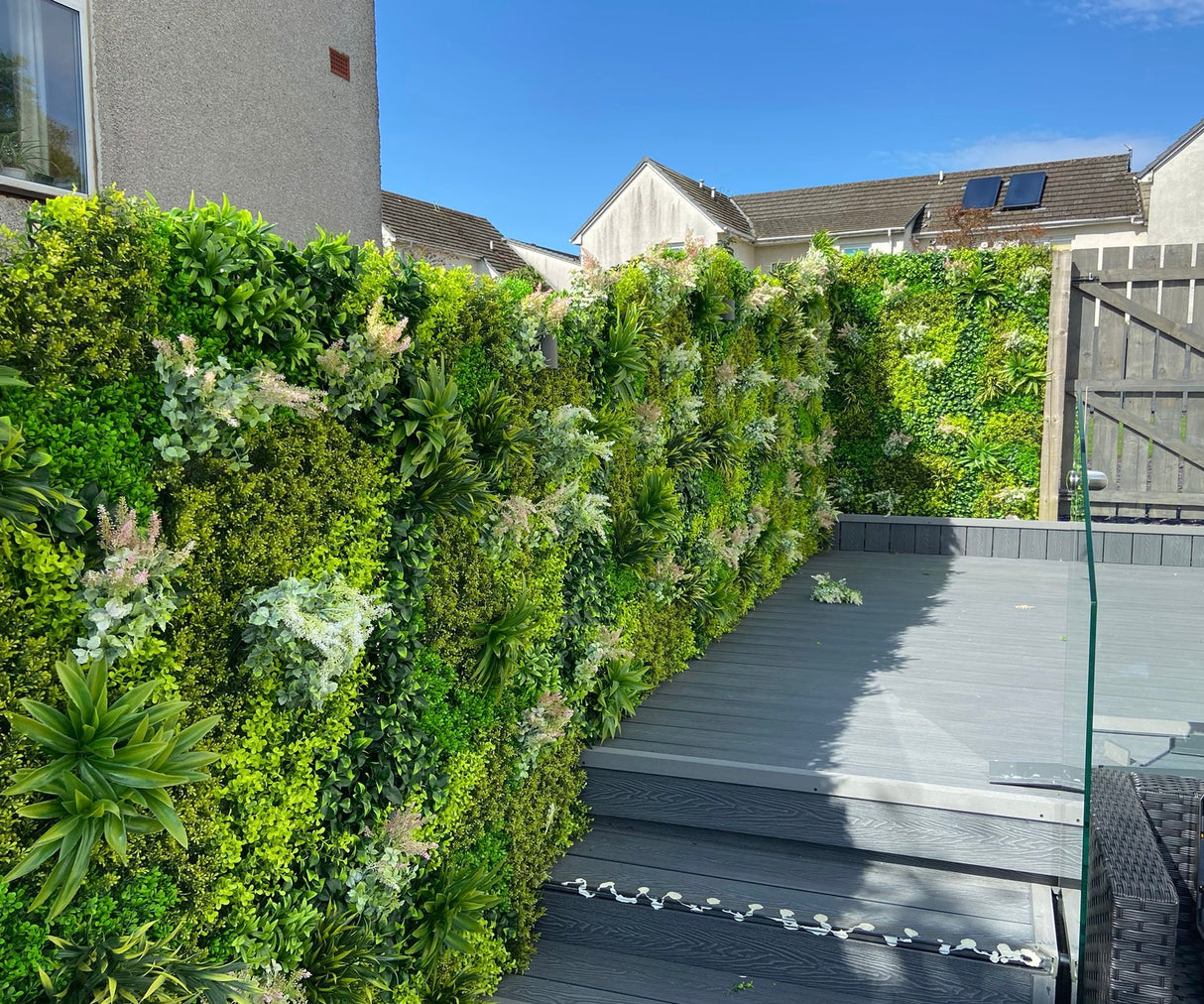 Artificial green wall panel varigated  green foliage  palms heads and white purple-pink flowering heads 100x100 cm