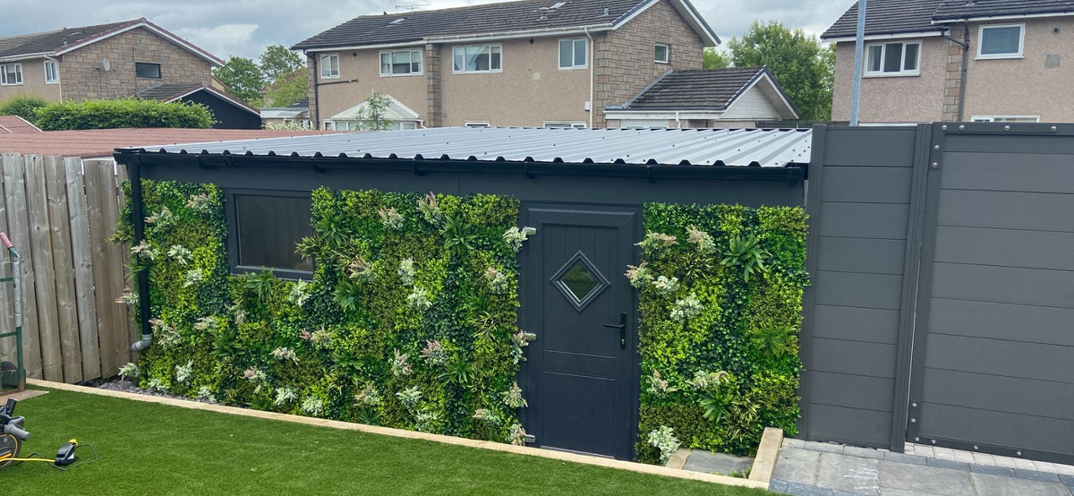 Artificial green foliage wall panel covering fence sections and a garden gate area