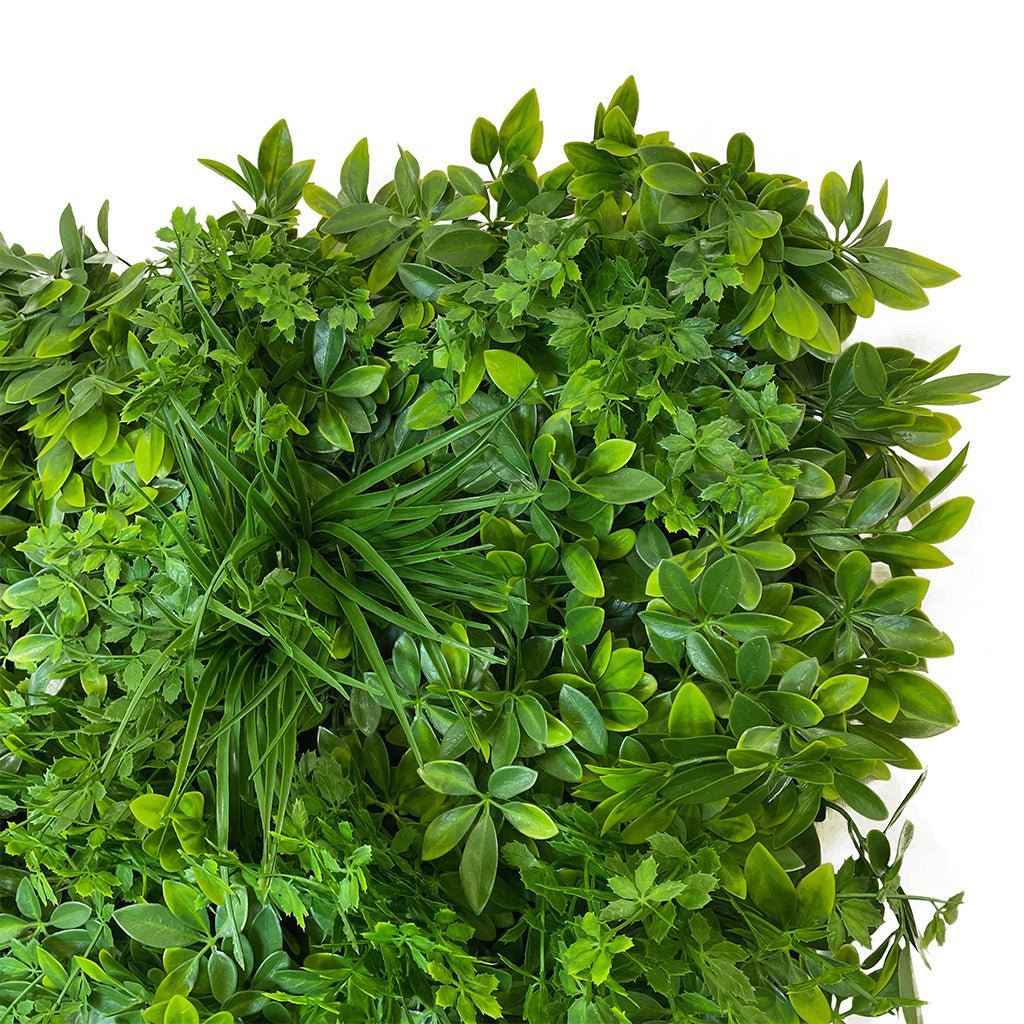 Artificial green wall foliage panel close-up, layered leaf sprigs with 3D texture