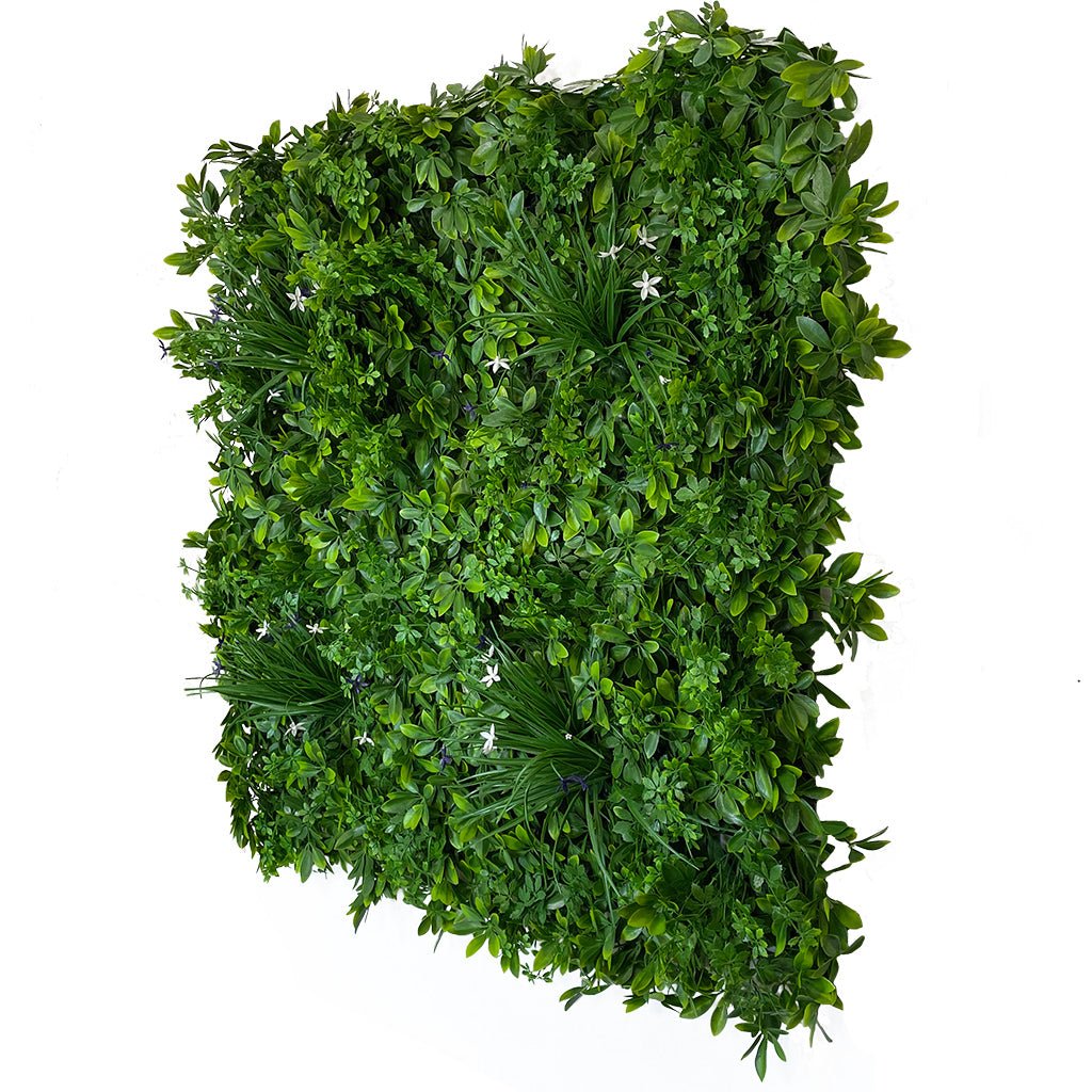 Artificial green foliage wall panel with dense textured leaves and scattered white flower accents