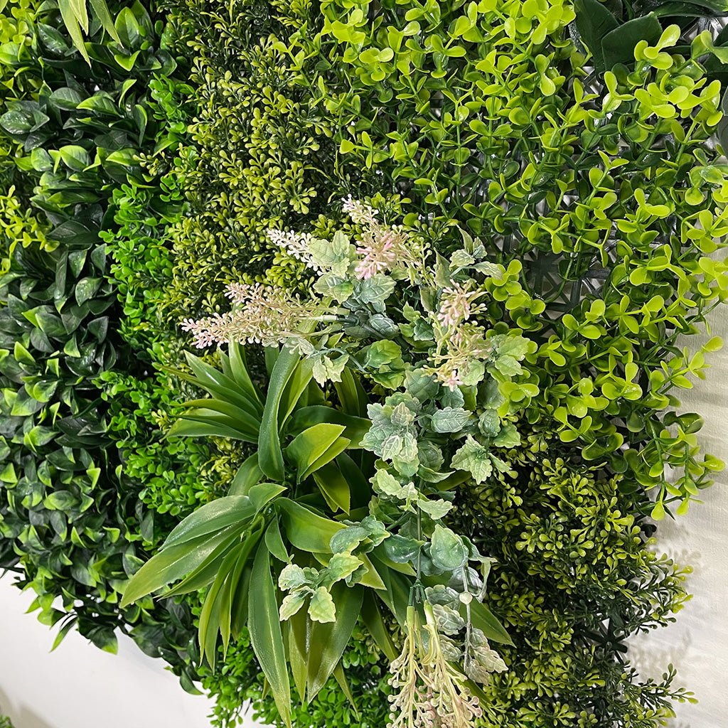 Artificial green foliage wall panel with pale flowering sprays and layered leaf textures