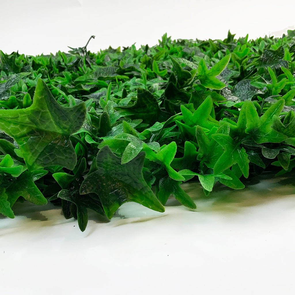 Artificial green wall plant panel with ivy foliage along the bottom edge