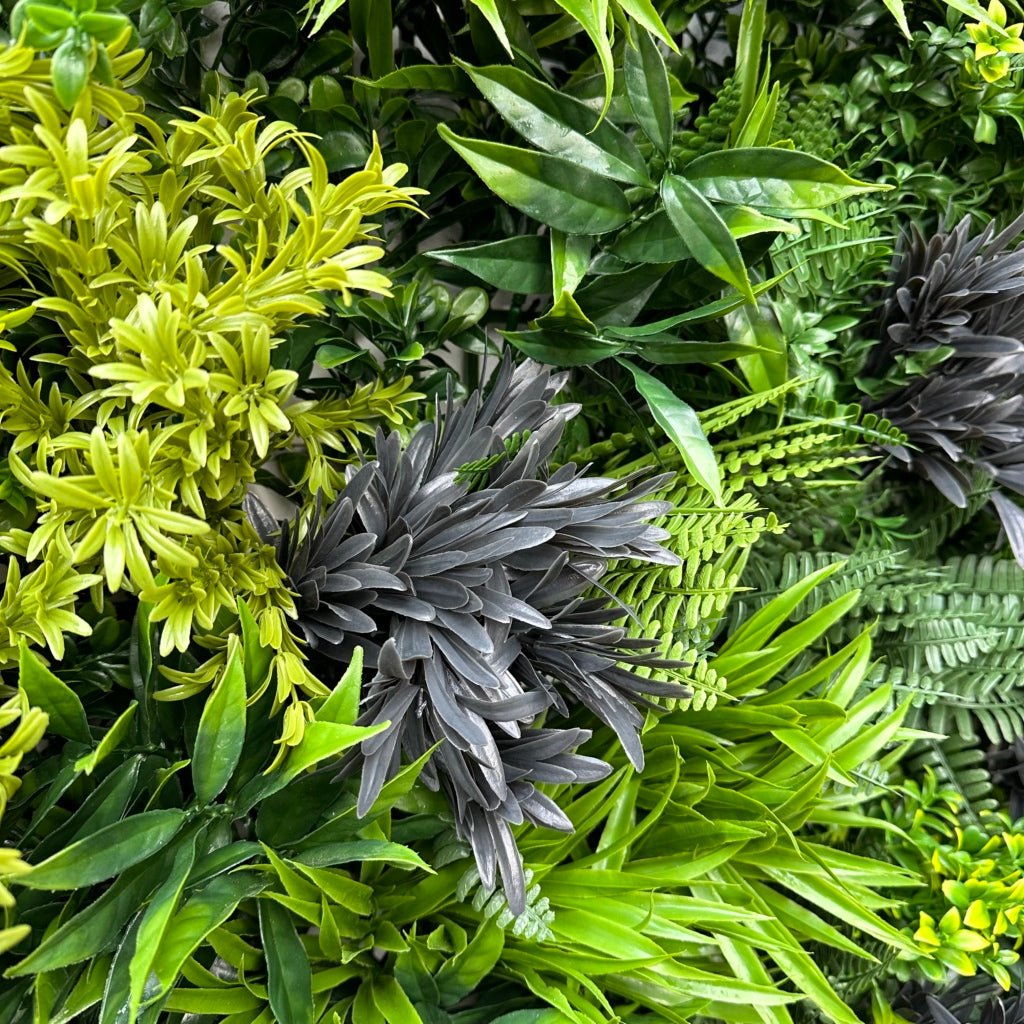 Green foliage wall panel close-up with broad leaves and spiky accents