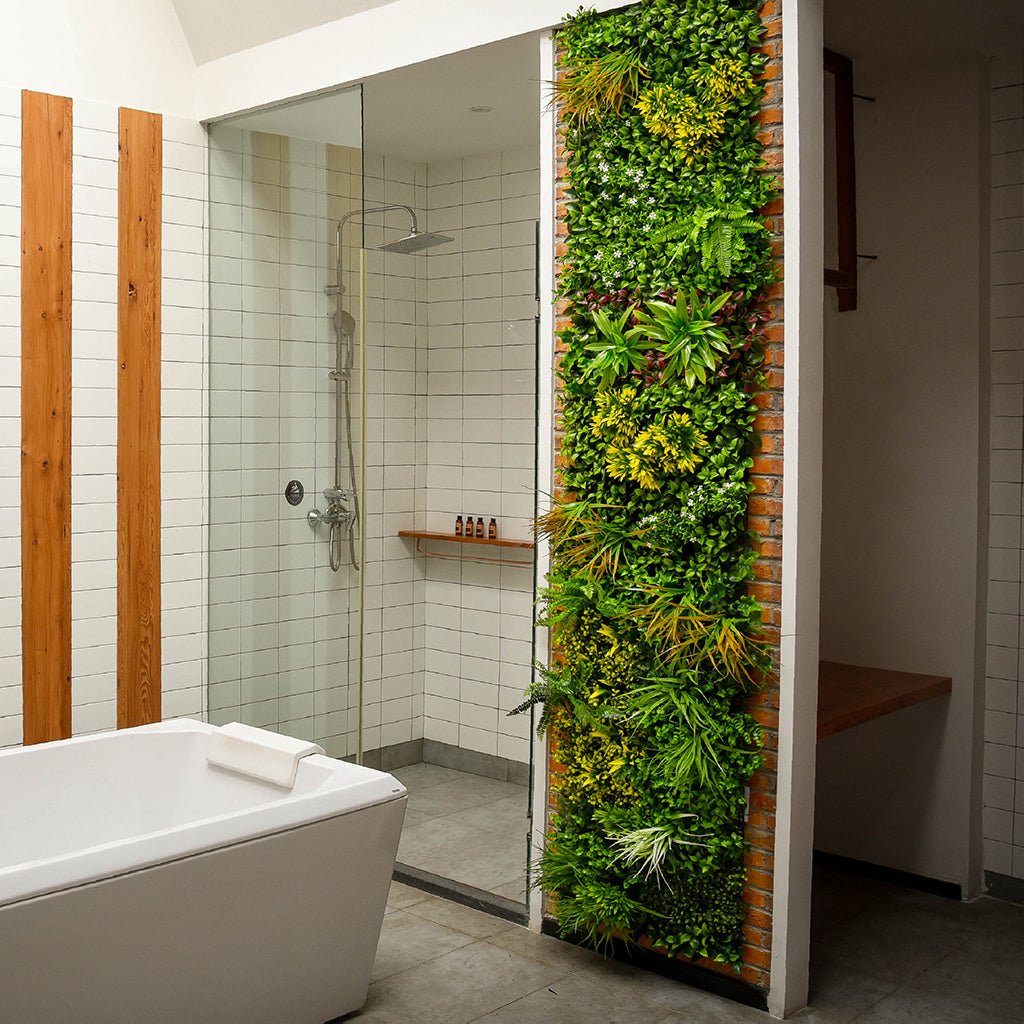 Artificial indoor green wall panel with lush mixed foliage filling a tall vertical section