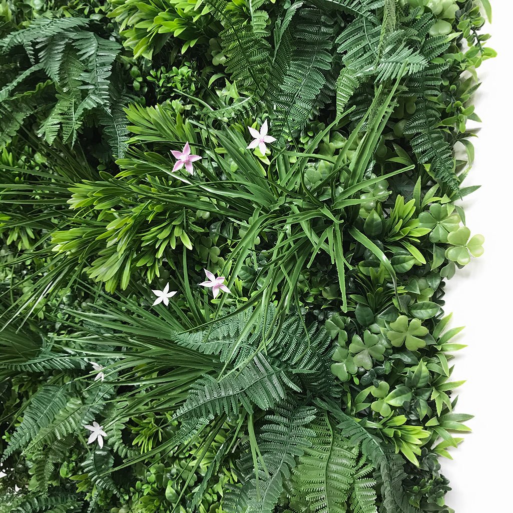 Artificial green wall panel with mixed foliage, light and dark leaves, pink flowers