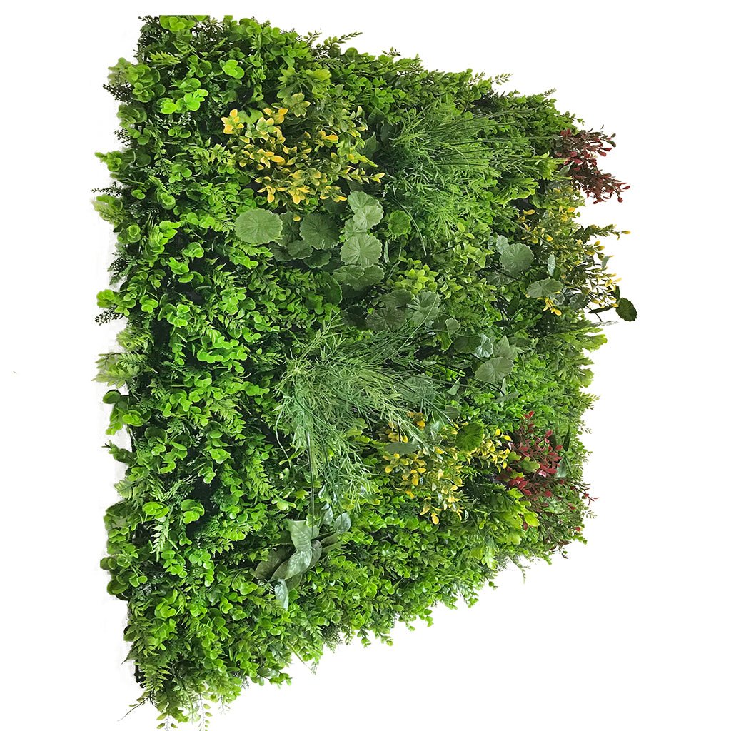 Artificial plant wall panel with dense green leaves, some yellow foliage, and red sprigs