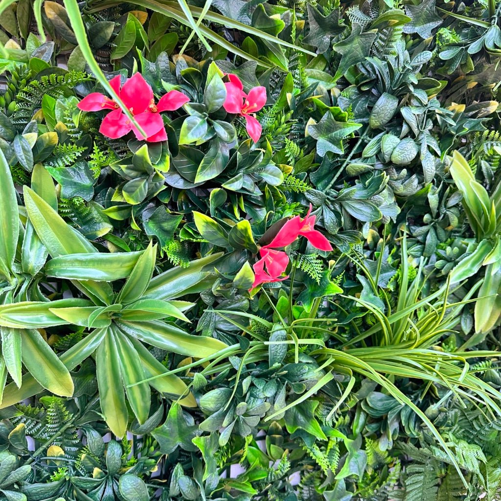 Artificial green foliage wall panel close-up of layered leaves with pink blossoms
