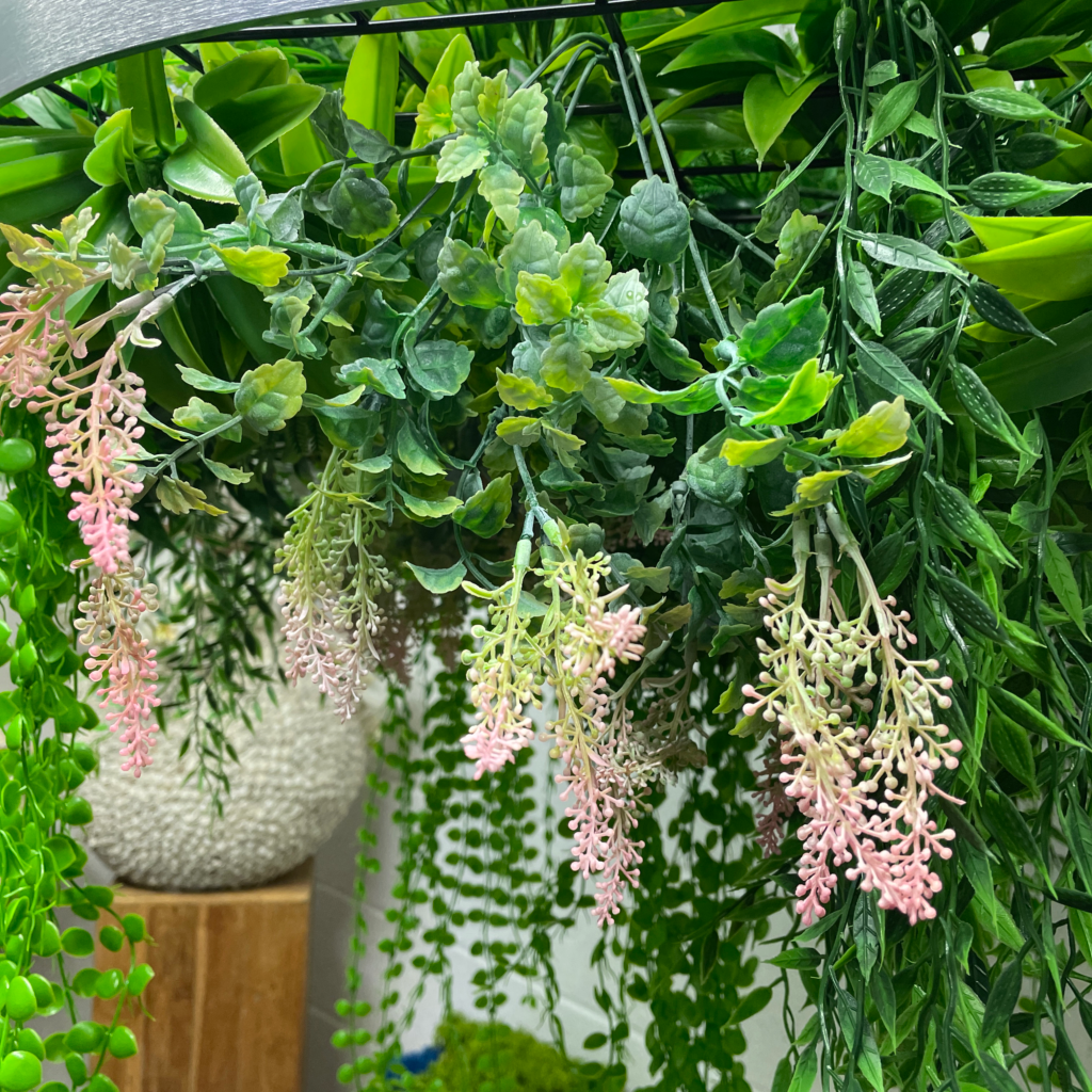 Hanging plant hoop with artificial green foliage and pink and white flower clusters