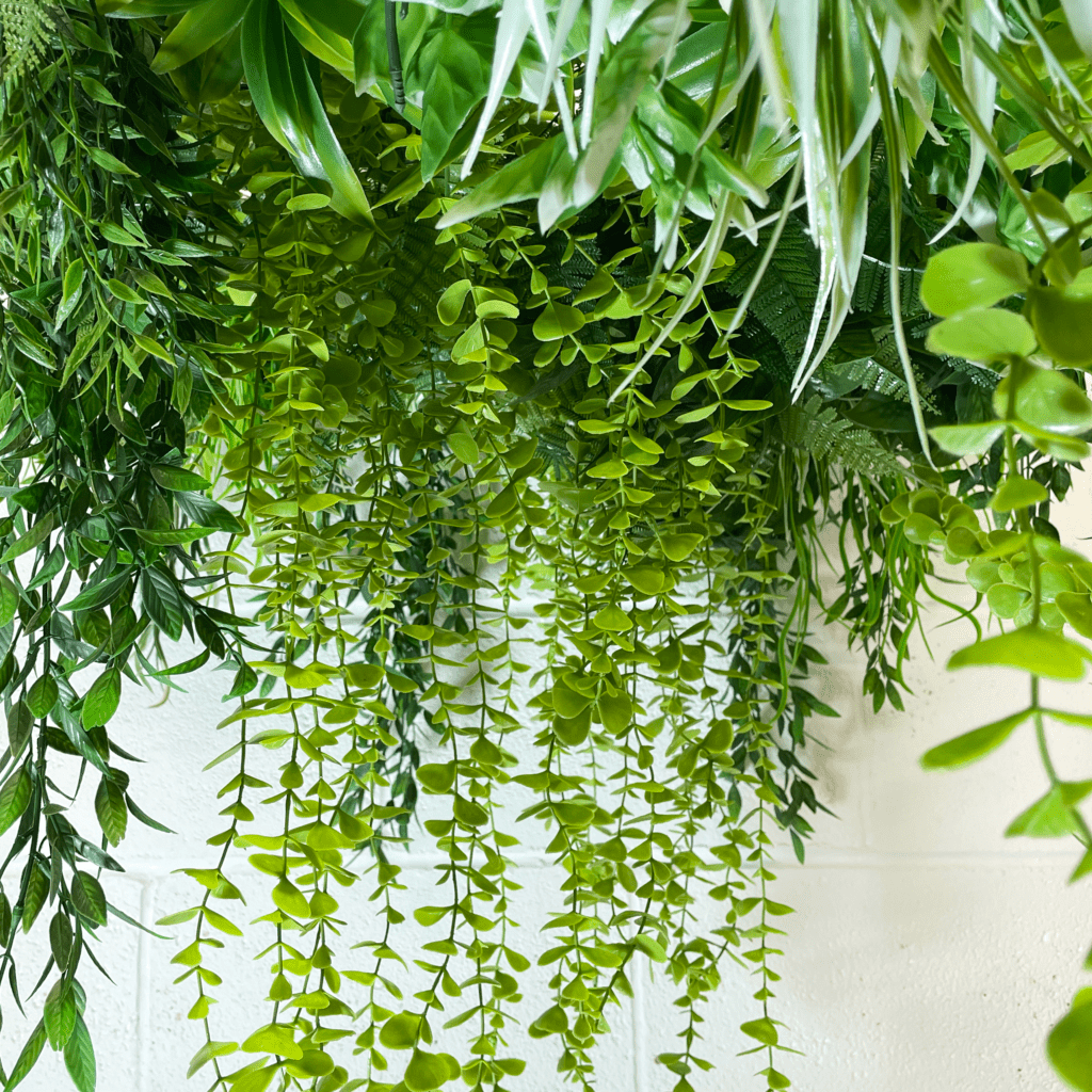 Artificial hanging greenery raft close-up with layered green leaf strands