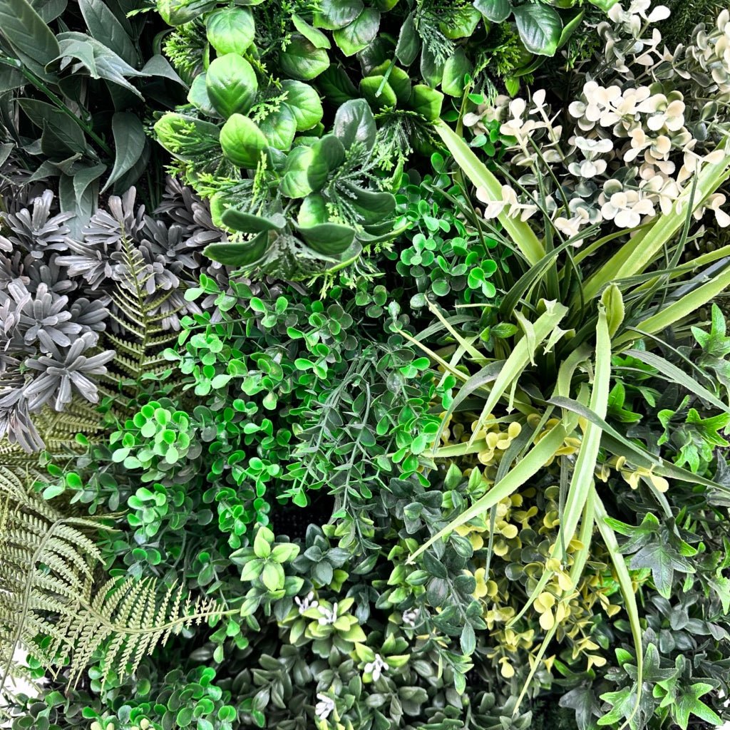 Artificial 3D plant wall panel close-up of green foliage with ferns and blade leaves
