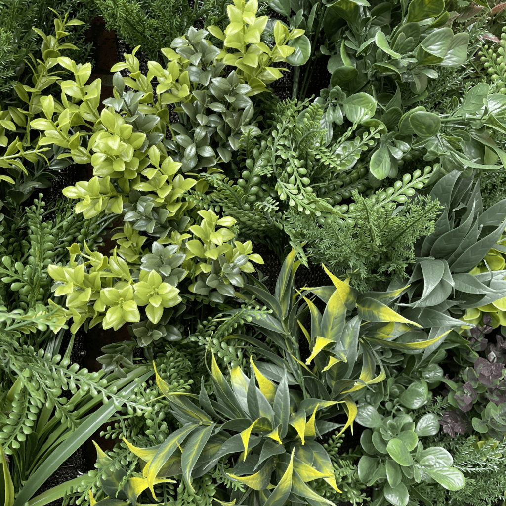 Artificial plant wall panel with layered green and chartreuse plants, dense bushy texture