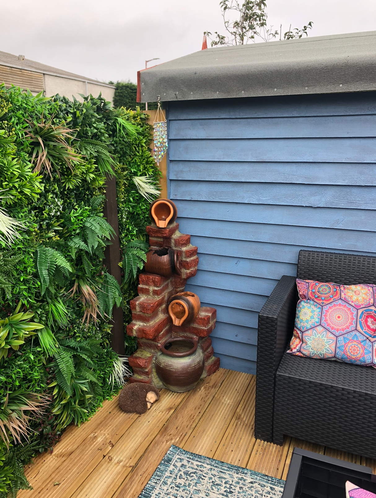 Artificial green foliage wall panel covering the outdoor corner fence section