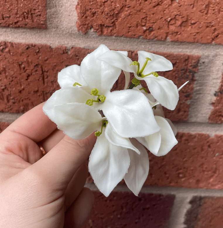Artificial white gardenia flower from the wall panel with green buds