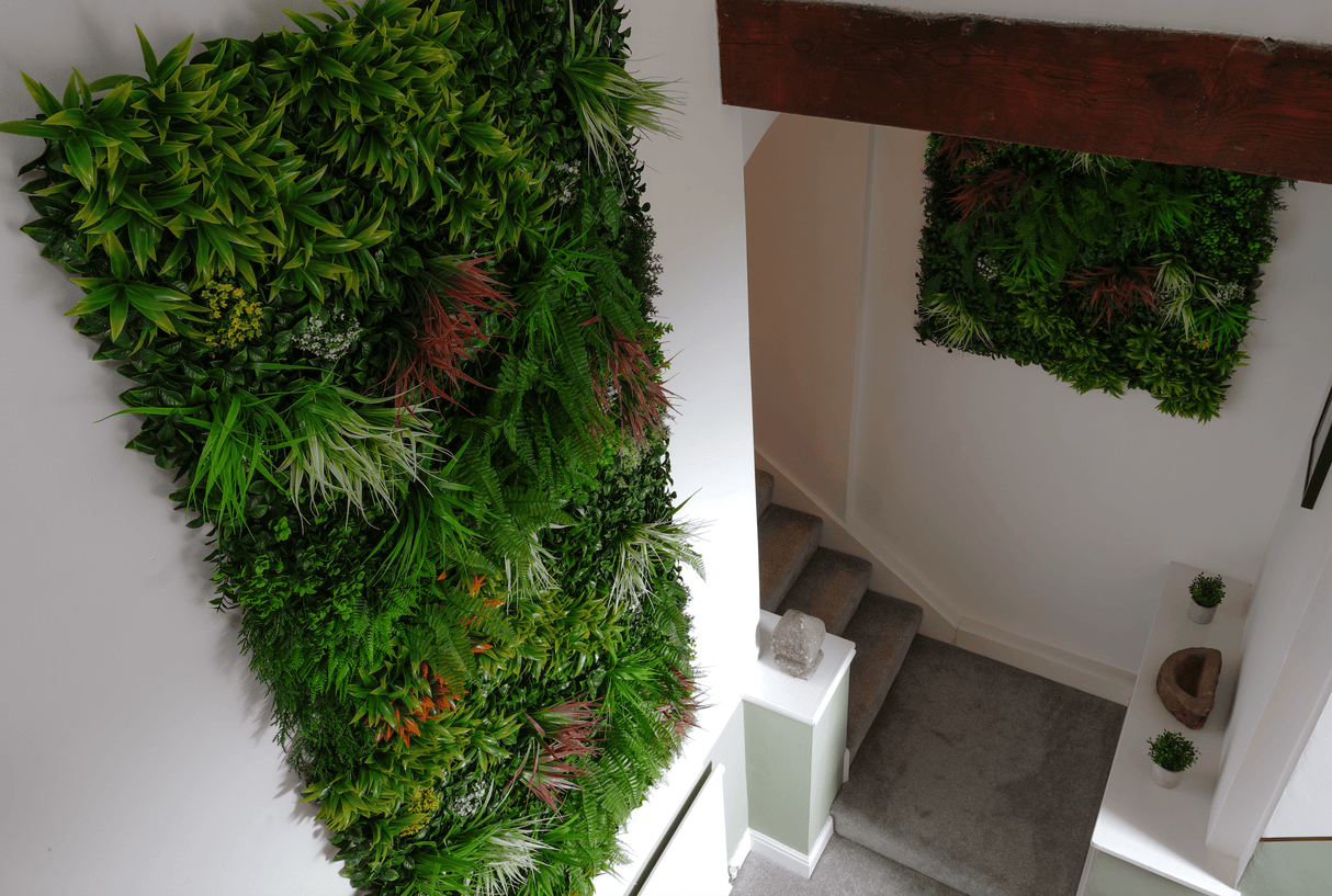 Artificial green foliage panel with dense leaves and visible mix of orange-red and white details