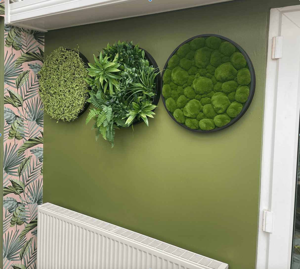 Black-ring circular foliage panels on a green wall, with one textured green panel