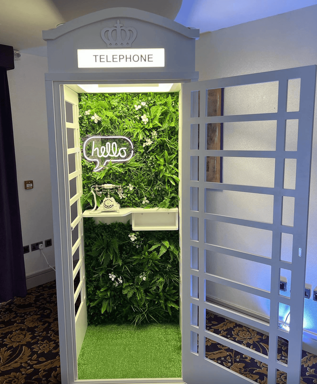 Artificial green foliage wall panel installed in a door opening, with white blossoms