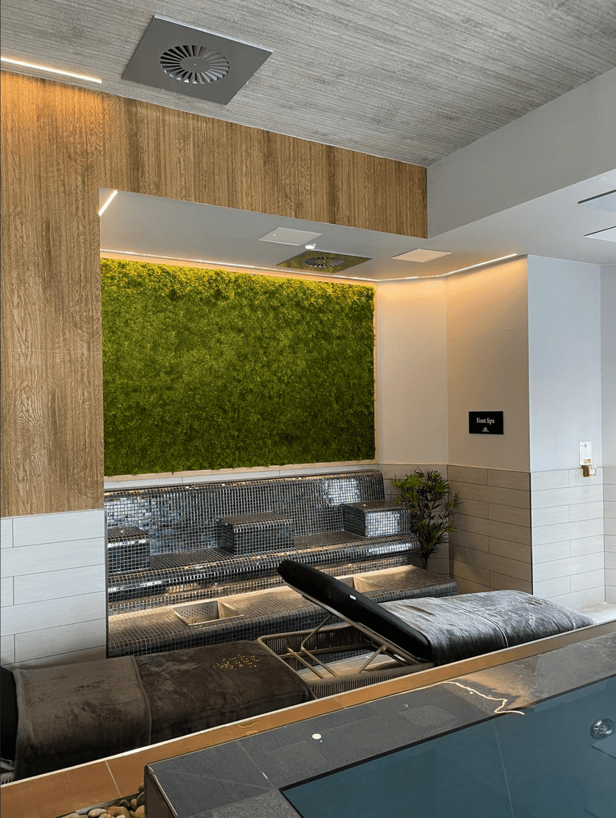 Artificial moss panel feature wall with green texture in indoor lounge area
