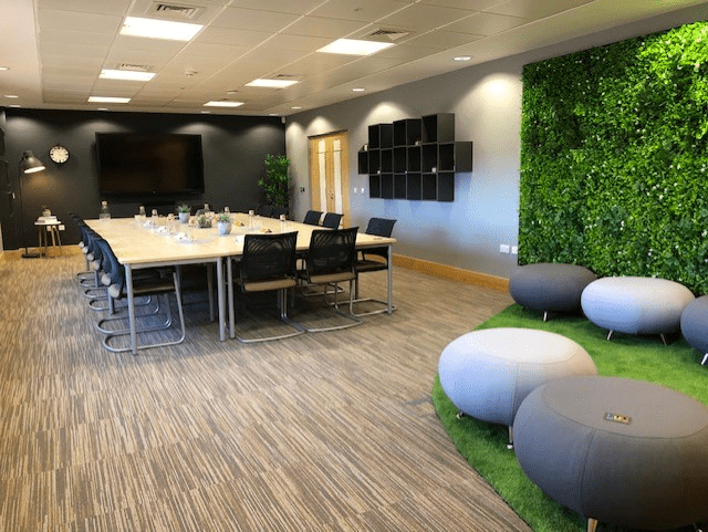 Artificial green plant wall panel installed on wall section with lush green foliage