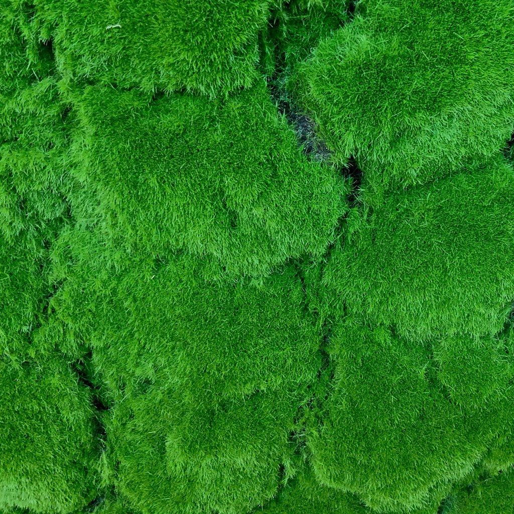 Artificial green moss panel close-up showing moss blocks and darker seams