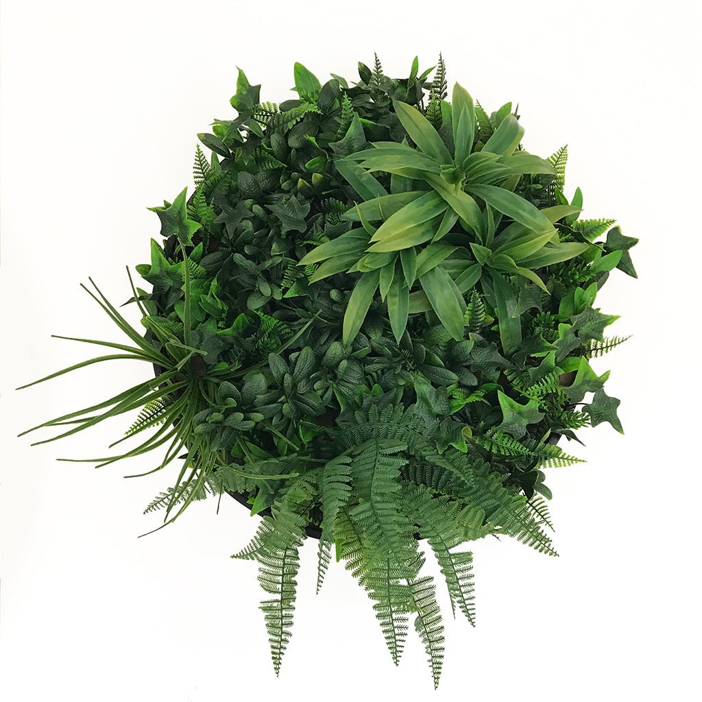 Black round artificial foliage panel with layered green leaves, ferns, and fronds
