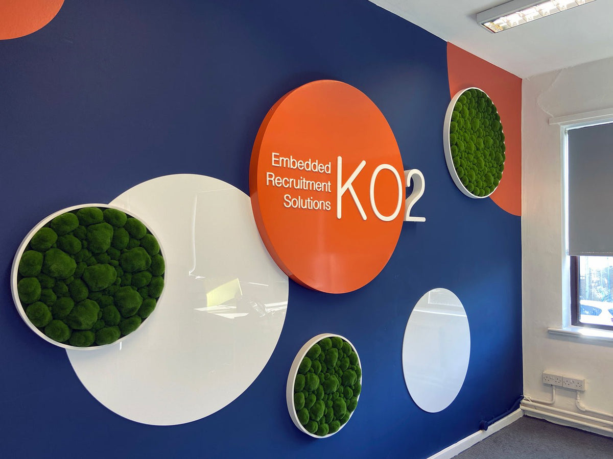 Green artificial moss circular wall art panels with dark frames.