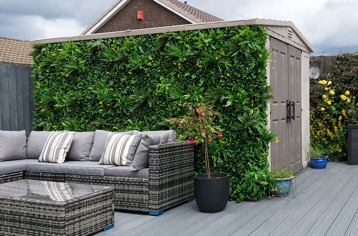 Artificial green wall panel with variegated greens of ivy, ferns, palm heads, grasses & small yellow flowers 100x100 cm