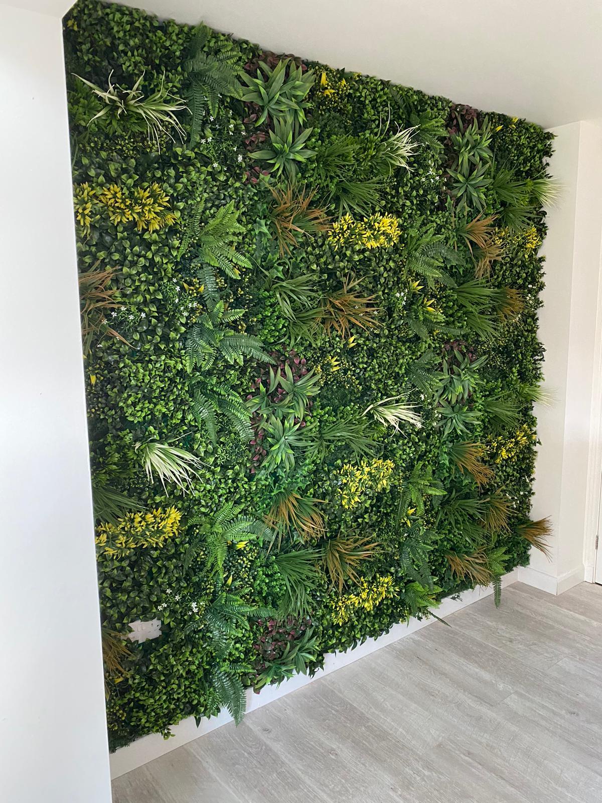 Artificial green wall panel with dense mixed plants and yellow-green highlights