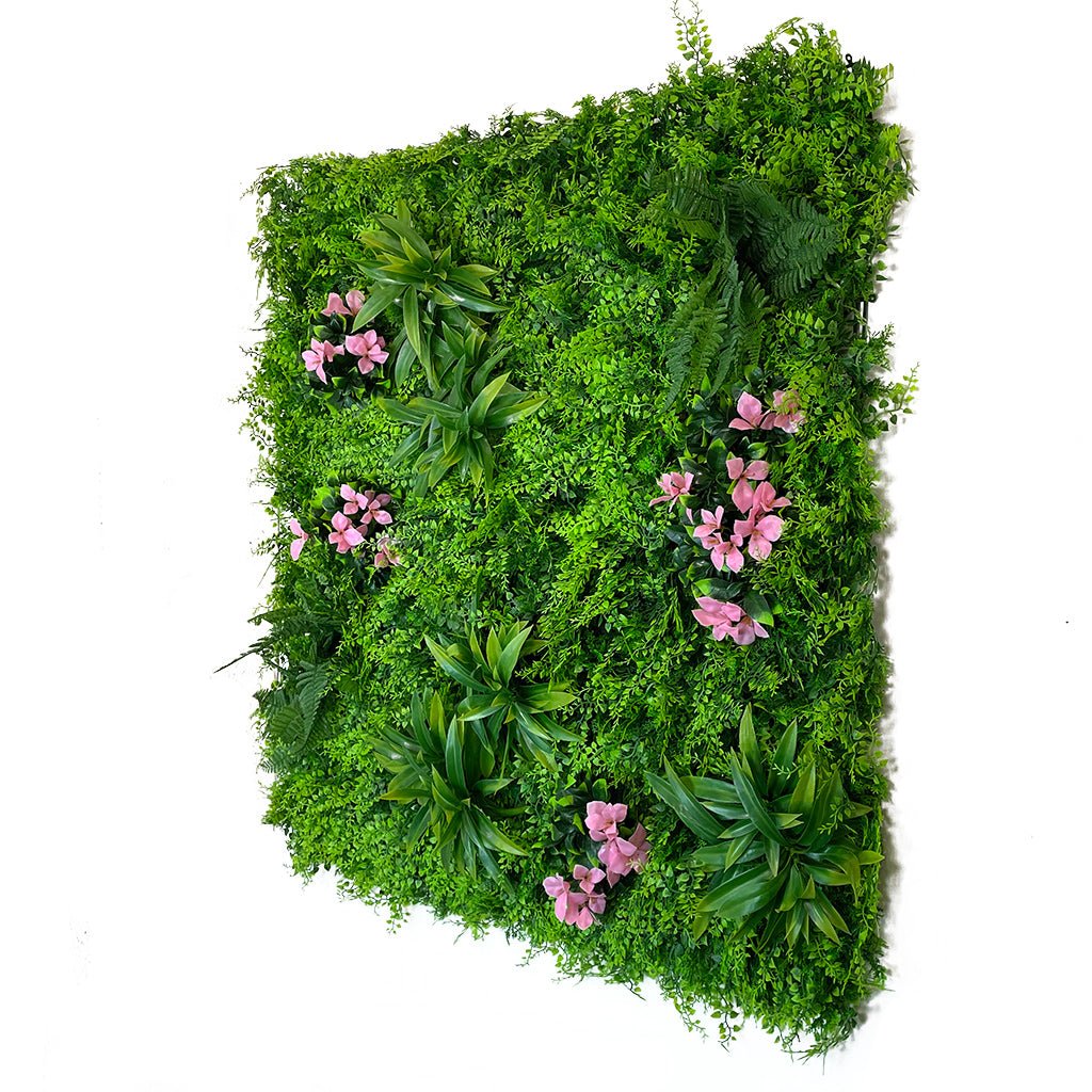 Artificial green wall panel with lush green foliage and scattered pink flowers