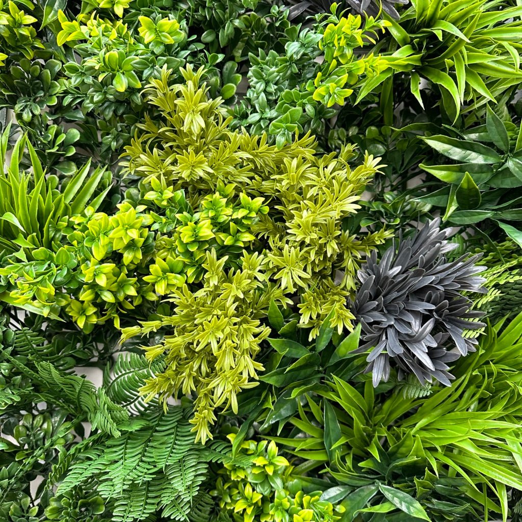 Green foliage wall panel close-up with layered grasses and dark spiky leaves